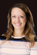 woman with long brown hair wearing striped shirt and smiling